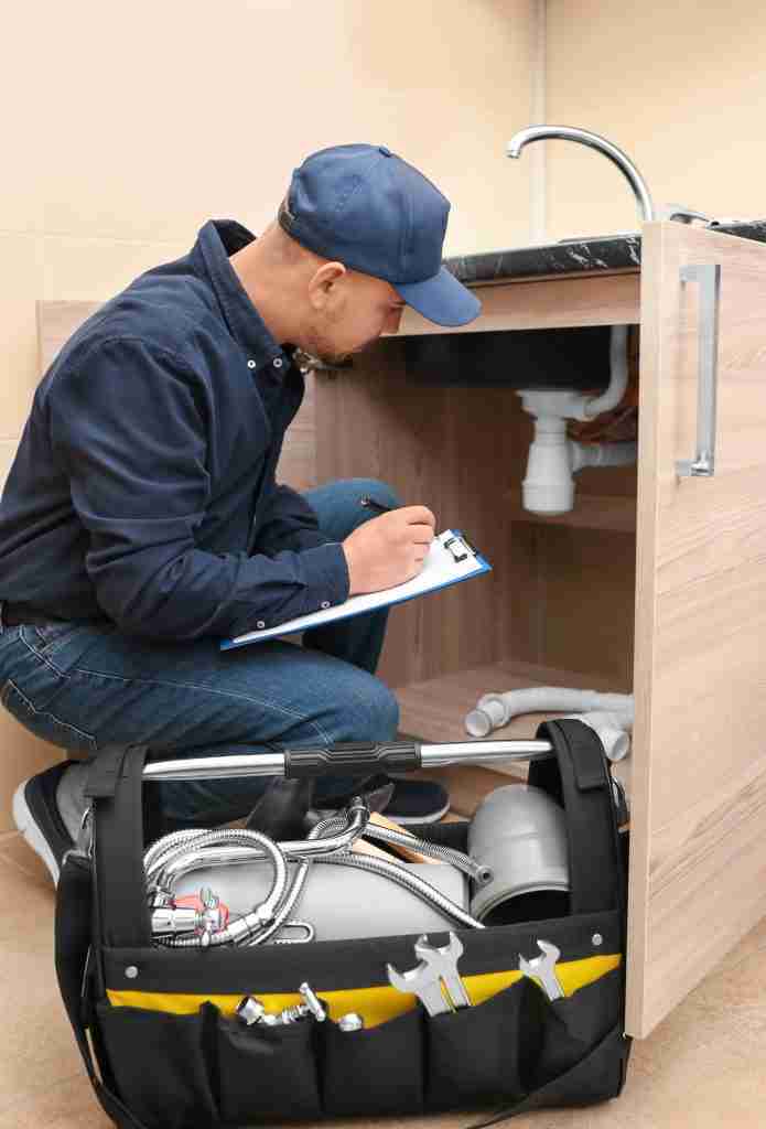 Plumber with set of tools and clipboard in kitchen Condo Plumbing Services in Toronto - 7