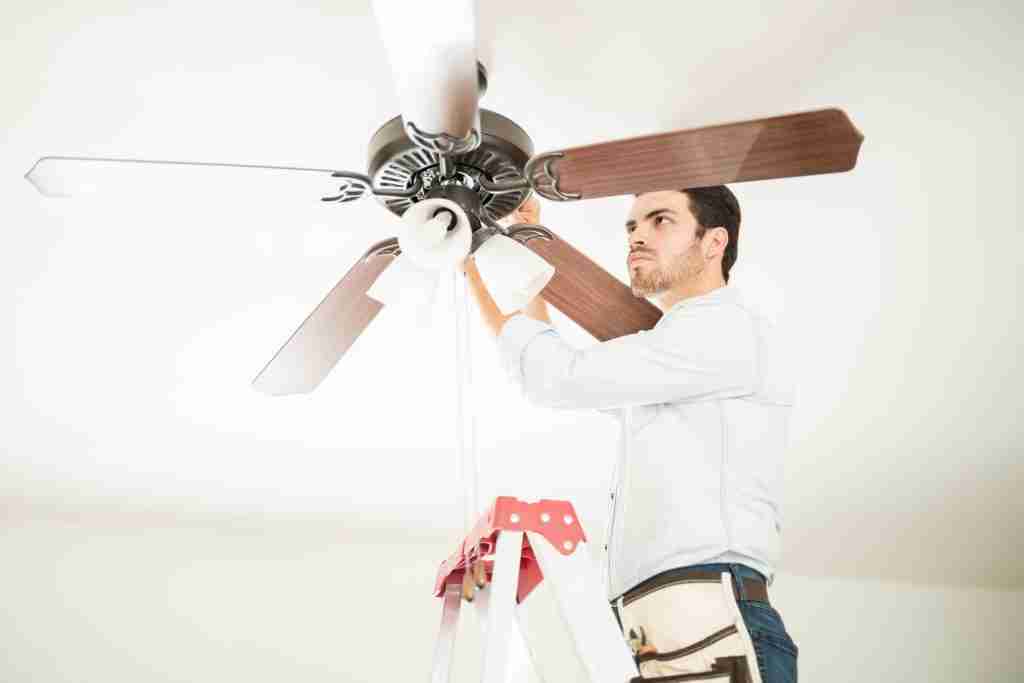 Man in ladder fixing ceiling fan Condo Lighting and Electrical Services in Toronto - 6