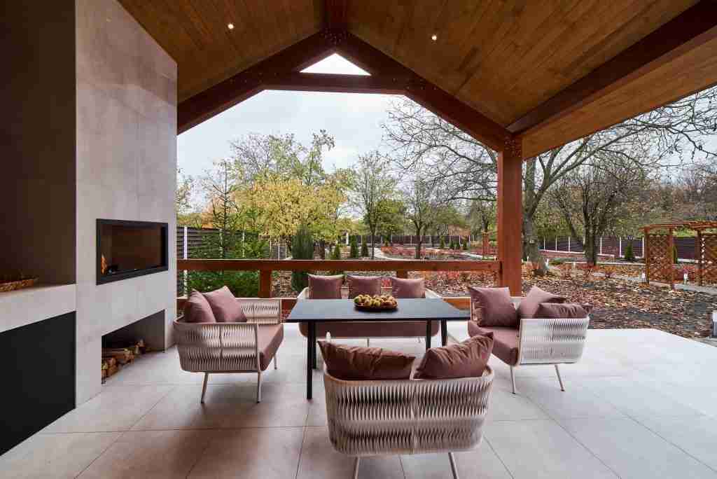 an open terrace with table, chairs, fireplace and apples Condo Balcony and Terrace Renovation in Toronto - 4